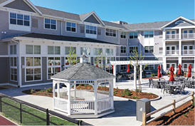A white gazebo is located in the middle of a courtyard between two buildings. AI generated content