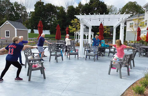 A group of people are playing a game of punching bags in a patio area. AI generated content